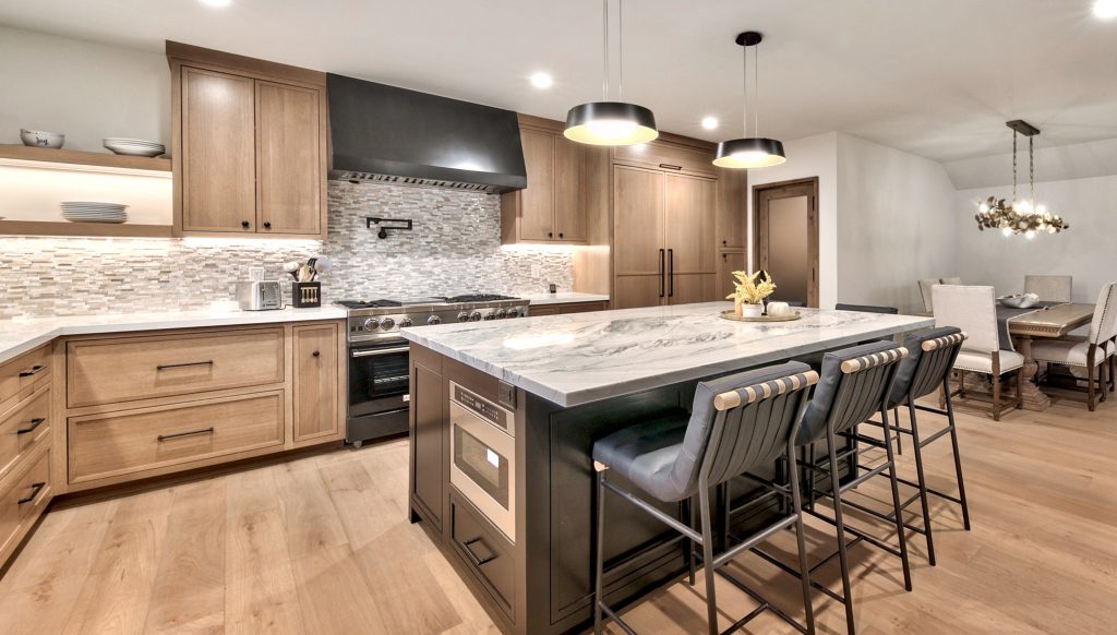 A spacious kitchen and island with stone countertops